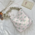 Détail de la bordure en dentelle et des nœuds verts sur un sac en tissu souple - Style Bandoulière à Base Rose (Sangle à Volants)