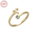 Anello in argento 925 placcato oro con lettera R e gemma blu su sfondo bianco pulito - Oro Ariete