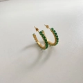 Detailed macro shot of gold hoop earrings set with emerald-cut green zircon stones - Green (DEK1084)