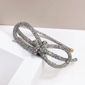 Detailed view of silver bow hairband featuring sparkling multi-colored rhinestones on base - AB Zircon