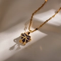 Detail of a purple heart crystal necklace with gold bow pendant on white silk fabric - Purple