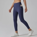 Detail view of high-waisted dark blue yoga pants with functional side pocket holding a phone - Dark Blue