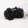 Detailed close-up of a large black chiffon flower hair claw clip with a plastic spring grip - Black