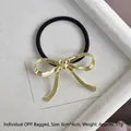 Close-up of a gold metal bow hair tie with dimensions 6cm by 4cm on a white tray - Gold Flat Bowknot