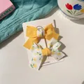 Two-piece yellow and floral bow hair clips for girls on a white display card - Yellow Patchwork Bow Set