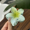Macro shot of mint green jelly frangipani flower hair claw clip with subtle glitter - Plumeria Jelly Texture / Mint Green