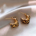 Gros plan de boucles d'oreilles léopard en C sur un fond de soie argentée luxueux - 52# Tige d'oreille en argent-Or-Forme en C-Plaqué or véritable