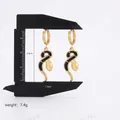 Elegant gold and black snake-shaped drop earrings featuring enamel finish and teardrop charm - Black & Gold