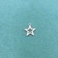 Macro shot of a hollow star stainless steel pendant with size dimensions 1.5cm x 1.3cm - Steel