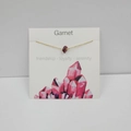 Delicate gold cross chain necklace featuring irregular garnet stone on a gift display card - Garnet