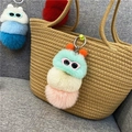 Schattige pluche rups sleutelhanger met zonnebril aan geweven tas, kleurrijke pluizige bollen - Groene Punt