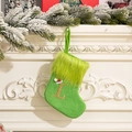 Green knit Christmas stocking with glitter letter L and fuzzy faux fur trim hanging on mantle - Letter L