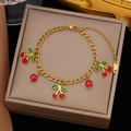 Elegant gold-tone stainless steel bracelet with cherry charms on a premium display box - Gold Stainless Steel Triple Cherry Bracelet (SLE2035)