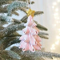Stacked candy-colored star tree Christmas ornament hanging on a snowy branch with bokeh - White Series - Star Topper