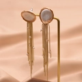 Elegant gold fringe earrings with white freshwater pearls on soft pink silk background - Flat Pearl Tassel Style