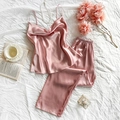 Conjunto de pijama de satén rosa con top de tirantes y pantalón sobre cama blanca - S / Rosa