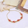 Adjustable golden Hamsa Hand bracelet with red enamel evil eye charms and crystals - Red