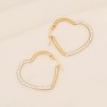Polished gold heart hoop earrings with sparkling crystal pavé on textured beige fabric - Heart