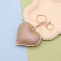 Close-up of beige PU leather heart keychain with gold metal ring on a display tray - Gold Chain Clasp / Gold