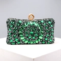 Detailed macro view of deep green crystals and pearl clasp on luxurious evening clutch bag - Green