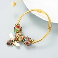 Golden twisted bangle featuring a sparkling bee pendant and colorful crystal charms - Colorful