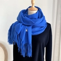Classic Klein blue cashmere-feel scarf with fringes on a black sweater model - Sapphire Blue