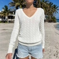 Women's white V-neck cable knit sweater with long sleeves and ribbed cuffs in beach setting - S / White