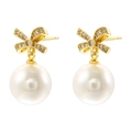 Elegante goldene Schleifenohrringe mit Perlen und Zirkonia auf weißem Grund - Strass Schleife Perlenstecker / Gold