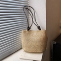 Handgewebte beige Stroh-Eimertasche mit dunkelbraunen Griffen und Holzkugel-Detail - Gebrochenes Weiß