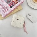 Detailed shot of quilted cream storage pouch with floral embroidery and pink zip pull - Colorful Flowers
