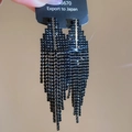 Makro-Detail geometrischer schwarzer Quastenohrringe mit funkelnden Kristall-Strasssteinen - Schwarz