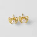 Détail de boucles d'oreilles papillon dorées avec perle blanche et ailes ajourées - Style Papillon de Perle
