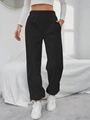 Dettaglio dei pantaloni sportivi neri con vita elastica e tasche laterali - S / Nero