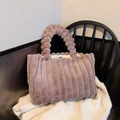 Fuzzy pink plush tote bag with striped texture and spherical handle on a black chair - Khaki