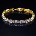 Elegant gold bracelet with square and round clear zircons on reflective black backdrop - Gold Plated White