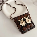 Detail der handgefertigten Kokosnussschalen-Tasche mit beige Blumen und Holzperlen - Dunkelkaffeeweiß