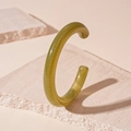Dettaglio del bracciale in acrilico verde oliva traslucido su una base in pietra naturale - Verde