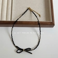 Detail of faceted black crystal necklace with bow pendant and gold clasp on a linen tray - 8# Black