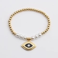 Bracciale a sfere dorate con perle e ciondolo a cuore malocchio su sfondo bianco - 0807YS-Malocchio Blu