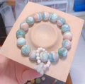Beaded bracelet with mint green and orange stones and heart charm in a wood tray - Beech Bracelet Tray 10x10cm