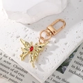 Elegant gold butterfly keychain with red gemstone on white stone backdrop - Red Rhinestone Gold Butterfly