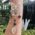 Detail of silver butterfly suncatcher with crystal pendants and green natural stone beads - India Agate