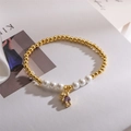 Dettaglio del bracciale a sfere dorate con perle e ciondolo a orso con zircone viola - Ciondolo Orso Viola