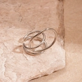Macro detail of geometric silver double-layer open ring on natural stone surface - Silver