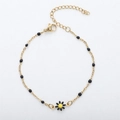 Detail of 18K gold daisy bracelet featuring black enamel beads and adjustable lobster clasp - Gold + Black