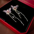 Macro shot of butterfly tassel earrings with pink gems and pearls in a jewelry box - Pink Butterfly Tassel Style (HE15651)