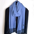 Detailed close-up of light blue cashmere scarf fringes on a dark tweed jacket - Denim Blue