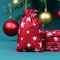 Detail of red linen Christmas drawstring gift bag with white star pattern and festive background - 10*14cm / Red Base Shining Star