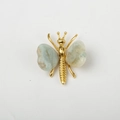 Golden butterfly brooch featuring natural grey-green crystal stone wings and polished metal - Amazonite