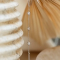 Macro detail of silver necklace featuring three round sparkling zircon stones on a fine chain - Silver Inlaid Zirconia Bracelet